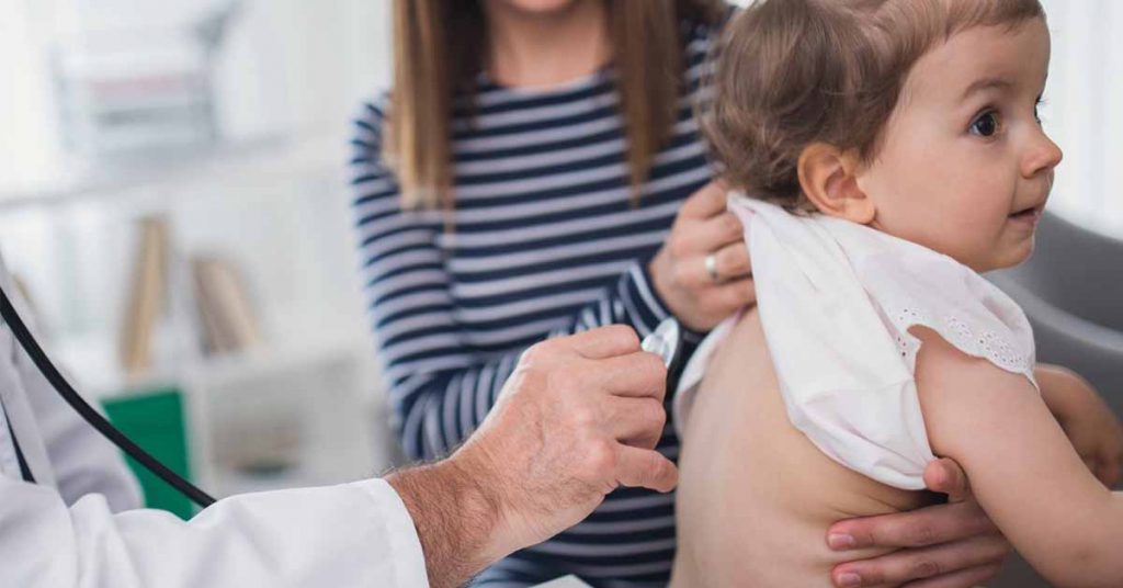 Pediatra em Catalão realizando consulta infantil em bebê, com acompanhamento próximo da família